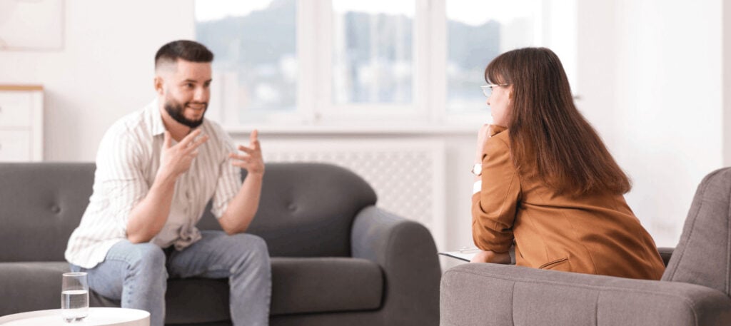A man discusses aftercare options with his therapist during medication-assisted treatment in Portland, OR.